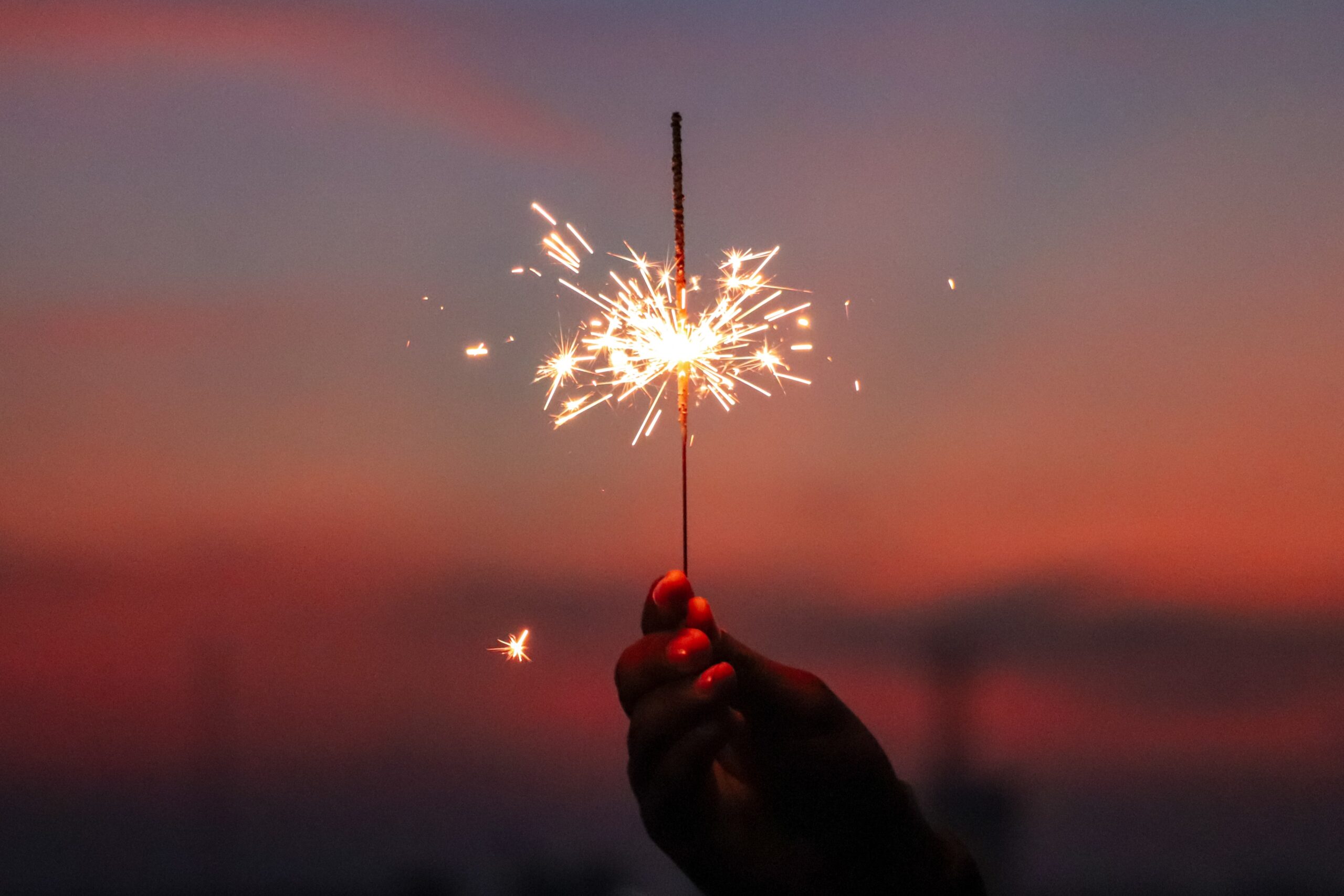 Leveraging Holidays for Luxury Real Estate Networking. Person holding sparkler.